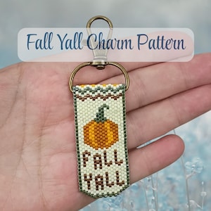 May include: A rectangular beaded keychain charm featuring a pumpkin graphic and the text Fall Yall in brown beads on a cream background with green and orange accents. The charm is attached to a bronze-toned metal lobster clasp and ring hardware.