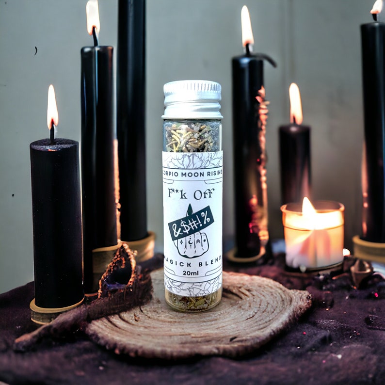 a vial of fuck off return to sender powder in front of black candles