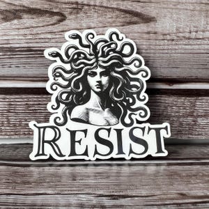 May include: Black and white sticker featuring a Medusa-like figure with snakes for hair and the word "RESIST" printed below.