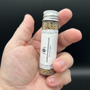 a vial in the palm of a hand to show scale