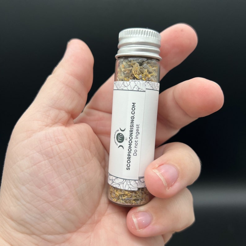 a vial in the palm of a hand to show scale