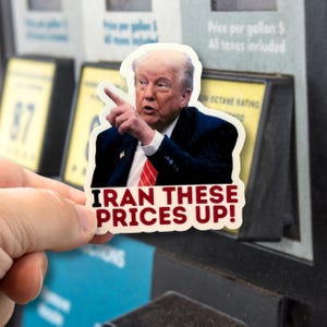 May include: A sticker featuring a portrait of a man in a suit and tie pointing. The sticker has the text "IRAN THESE PRICES UP!" in red letters. The background includes a gas pump.