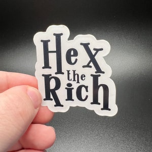 Puede incluir: Pegatina blanca con texto negro que dice "Hex the Rich".