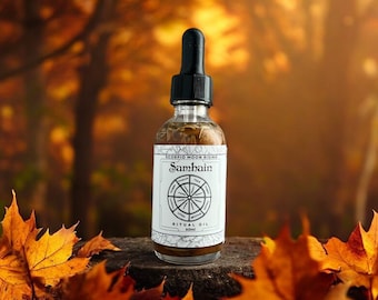 May include: A clear glass bottle with a black dropper lid and a white label. The label says "Scorpio Moon Rising Samhain Ritual Oil 60ml". The bottle is sitting on a wooden surface with autumn leaves around it.