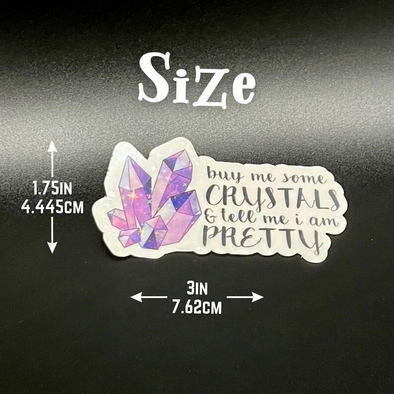 May include: A sticker with a crystal design in shades of purple and pink, with the text "buy me some CRYSTALS & tell me i am PRETTY." The sticker is 3 inches wide (7.62cm) and 1.75 inches tall (4.445cm).