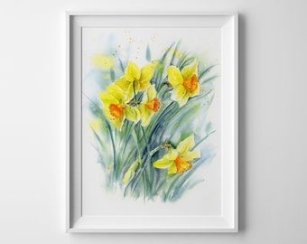 May include: A framed watercolor painting featuring a cluster of bright yellow daffodils with orange centers and green stems. The artwork is displayed in a simple white frame, showcasing loose, expressive brushstrokes and soft blue-green washes.
