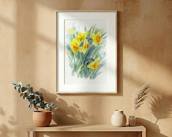 May include: A framed watercolor print featuring yellow daffodil flowers with green stems and leaves. The artwork is displayed in a simple white frame, showcasing vibrant yellow petals and soft green foliage against a white background.
