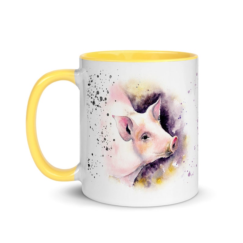 May include: A white ceramic mug with a yellow rim features a watercolor painting of a pink pig with a watercolor background. The pig is looking to the right and has a pink nose and ears.