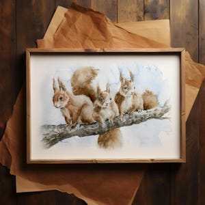 Könnte beinhalten: Aquarellmalerei von drei roten Eichhörnchen, die auf einem Ast sitzen. Die Eichhörnchen schauen den Betrachter mit ihren buschigen Schwänzen hinter sich an. Der Hintergrund ist ein hellblauer Aquarell-Wasch.