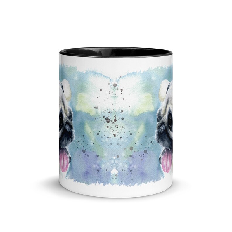 May include: White ceramic mug with a black rim featuring a watercolor illustration of a pug dog with its tongue sticking out. The background is a blue and green watercolor wash with white splatters.