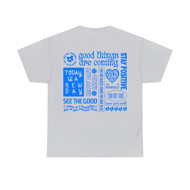 May include: A light gray t-shirt with a blue graphic print of motivational text. The text includes phrases like "good things are coming", "today is a new day", "see the good", and "stay positive".