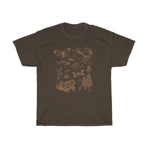 May include: A brown t-shirt with a print of various forest creatures, including frogs, butterflies, mushrooms, and dragonflies. The print is in a light brown color.