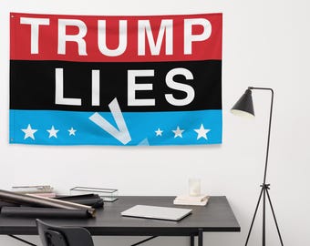 May include: A blue, black, and red flag with the text "TRUMP LIES" in white letters. The flag has five white stars on each side of a white, angled arrow.