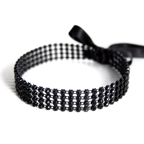 BLACK CRYSTAL CHOKER - Precious choker with black stones on a moving grid and double face satin ribbons for closure.