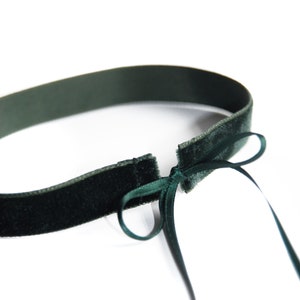 Könnte beinhalten: Ein dunkelgrüner Samt-Choker mit einer Schleife. Der Choker ist aus einem weichen, luxuriösen Stoff gefertigt und lässt sich an die meisten Halsgrößen anpassen.