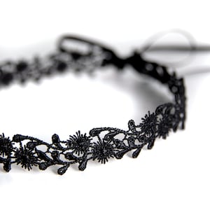 Könnte beinhalten: Eine schwarze Spitzenhalskette mit einem zarten Blumenmuster.