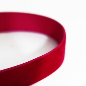 Pu&ograve; includere: Primo piano di un nastro di velluto rosa acceso.