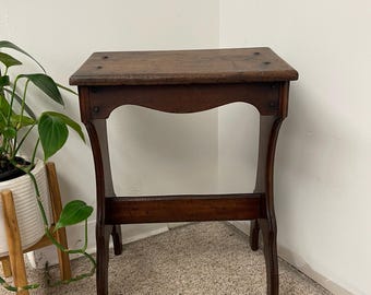 Sgabello decorativo in legno vintage con silhouette curva e dettagli dei pioli a vista