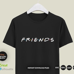 以下が含まれることがあります： 白い文字で「FRIENDS」と書かれた黒いTシャツ。文字の間にはカラフルな点が並んでいます。テキストはTシャツの中央に配置されています。Tシャツは白いハンガーにかけられています。