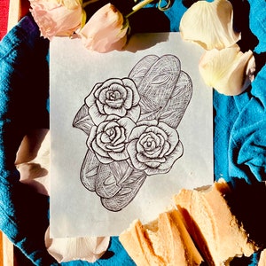 May include: A black and white line drawing of three roses and a pair of baguettes on a white background. The roses are drawn with intricate detail, and the baguettes are drawn with a more simple style. The drawing is surrounded by white rose petals.