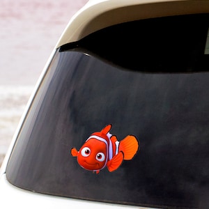 May include: A red and white cartoon fish with a smiling face, a black eye, and white stripes. The fish is on a black background.