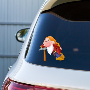 May include: A white car with a blue window and a sticker of a cartoon dwarf with a pickaxe. The dwarf is wearing a red and blue outfit and has a white beard.