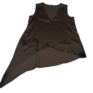 Peut inclure: Un haut sans manches, marron fonc&eacute;, avec un col en V. Le haut a un ourlet asym&eacute;trique, un c&ocirc;t&eacute; &eacute;tant plus long que l'autre. Le tissu a un l&eacute;ger &eacute;clat, lui donnant un aspect soyeux. Ce v&ecirc;tement est adapt&eacute; &agrave; diverses occasions.