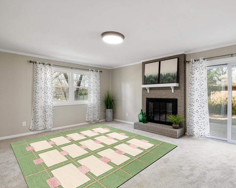 May include: A living room with a green and cream-colored rug, a fireplace, and a window with white curtains. The rug has a geometric pattern with rectangular cream-colored shapes and pink accents. The fireplace is brick with a black firebox.