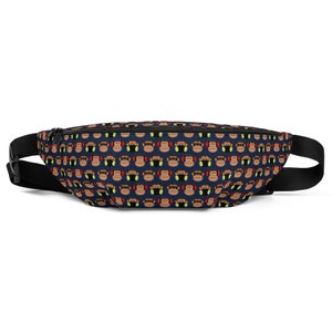 May include: A navy blue fanny pack with a repeating pattern of cartoon monkey faces wearing headphones. The fanny pack has a black adjustable strap and a black zipper closure.