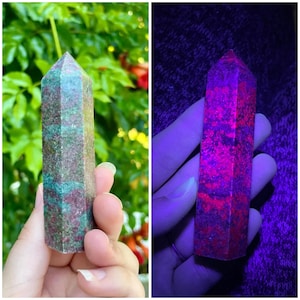 May include: A gemstone obelisk with a faceted top. The obelisk has a mottled appearance with green and brown tones. The second image shows the obelisk under a black light, revealing a vibrant red and purple pattern.