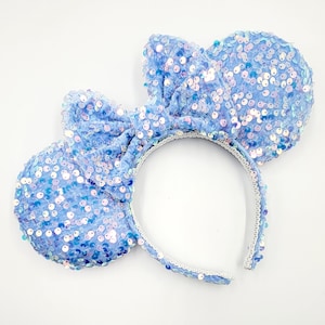 May include: Light blue sequined headband with a bow and mouse ears. The headband is made of a soft, flexible material and is perfect for adding a touch of whimsy to any outfit.