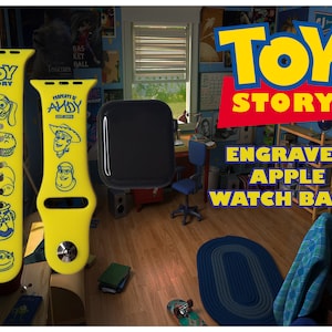 May include: Yellow and blue Apple Watch band with Toy Story characters engraved on it. The band is shown next to a black Apple Watch. The background is a room with a blue wall and a wooden floor.