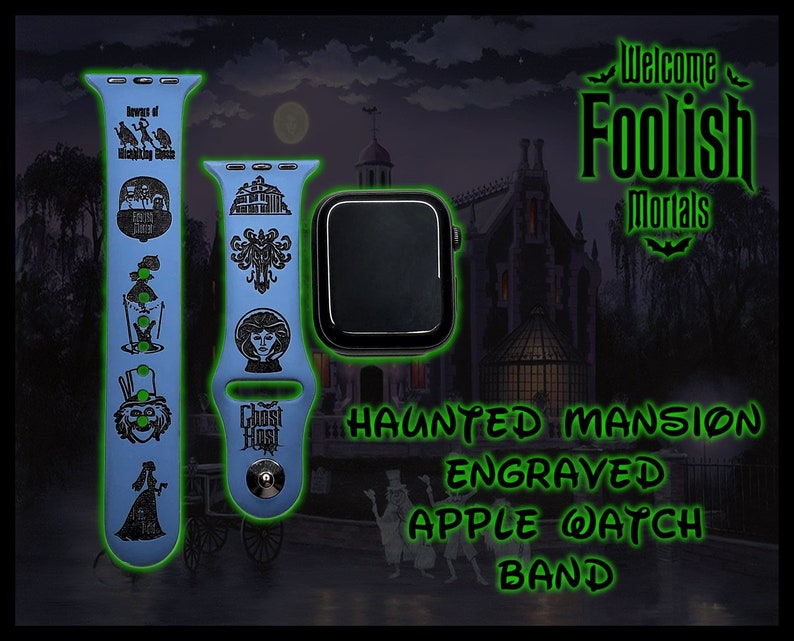 May include: A blue Apple Watch band with an engraved design featuring characters and imagery from the Haunted Mansion attraction at Disneyland. The band features the text "Ghost Host" and "Welcome Foolish Mortals". The text "Haunted Mansion Engraved Apple Watch Band" is displayed in green.