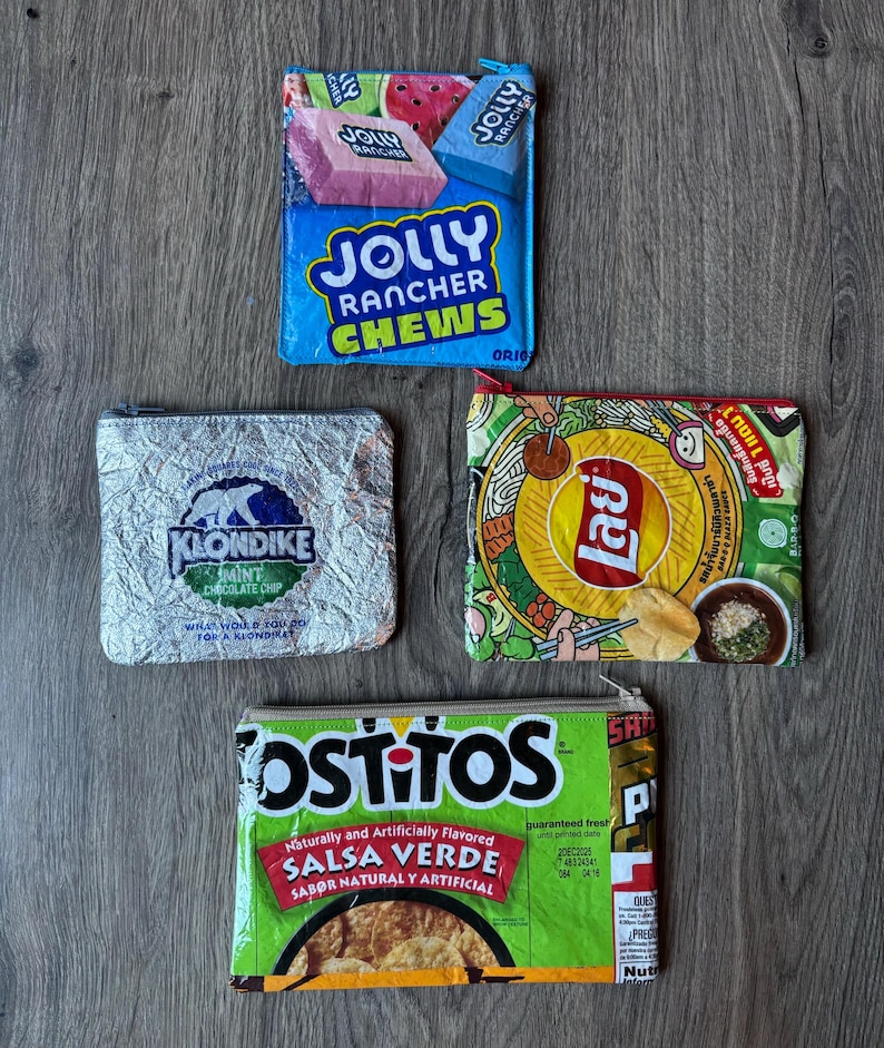 May include: Four small zippered pouches made from repurposed food packaging. The pouches feature the logos and designs of Jolly Rancher Chews, Klondike Mint Chocolate Chip, Lay's, and Tostitos Salsa Verde. The pouches are rectangular and have a zipper closure.