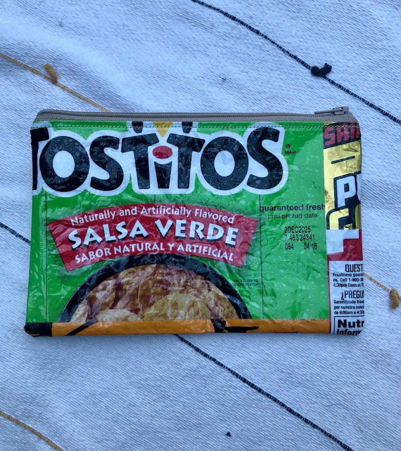 May include: Green and white zippered pouch made from a repurposed Tostitos Salsa Verde bag. The pouch features the Tostitos logo and text "SALSA VERDE" in red. The pouch has a silver zipper and a printed expiration date.