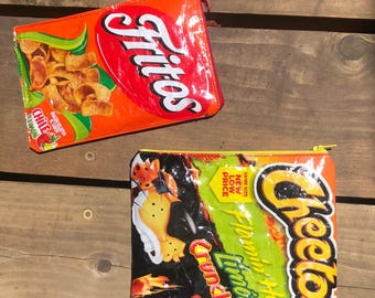 May include: Two rectangular zippered pouches made from repurposed snack bags. The top pouch features a red and orange Fritos Chili Limon design. The bottom pouch displays a black, green, and orange Cheetos Flamin' Hot Limon graphic with text.