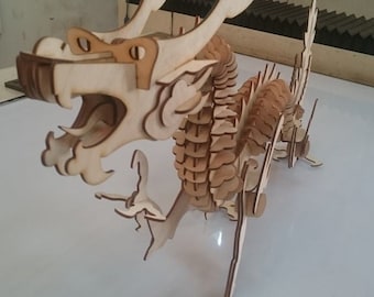 May include: A wooden dragon model kit, assembled and ready to display. The dragon is made of multiple pieces of wood that are intricately cut and joined together. The dragon has a long, serpentine body with a large head and wings. The dragon is painted in a natural wood color.