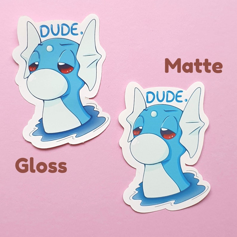May include: Two stickers featuring a cartoon blue sea creature with red eyes and the word "DUDE." above its head. One sticker is labeled "Gloss" and the other "Matte."