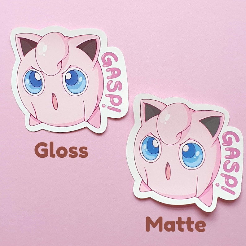 May include: Two stickers featuring a pink cartoon character with large blue eyes and the word "GASP!" in pink. One sticker is labeled "Gloss" and the other "Matte". The background is a solid light pink.