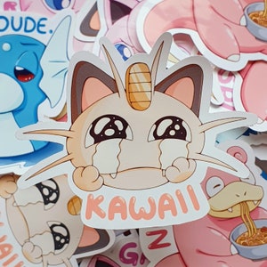May include: A collection of colorful stickers featuring various cartoon characters. The central sticker depicts a crying cat-like creature with the word "KAWAII" in pink. Other stickers include a blue dragon and a pink creature eating noodles.