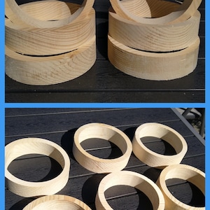 Könnte beinhalten: Eine Sammlung von unbehandelten, hellen Holzringen mit einem glatten, kreisförmigen Design. Diese runden Holzbänder weisen eine natürliche Maserung und eine gleichmäßige Dicke auf und sind sowohl gestapelt als auch einzeln angeordnet.