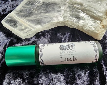 May include: A green glass roller bottle with a white label that says "Life Spirits" and "Luck". The bottle is sitting on a black velvet surface with a clear crystal next to it.