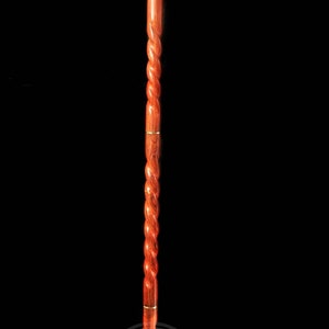 Pode incluir: Uma bengala de madeira com uma pega em forma de cabe&ccedil;a de lobo. A bengala &eacute; de cor castanho-avermelhada e tem um design torcido. A cabe&ccedil;a de lobo &eacute; feita de metal e tem um acabamento dourado.
