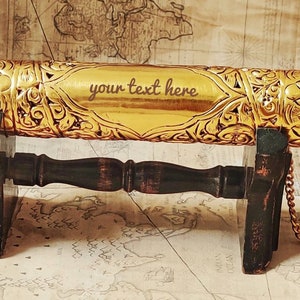 May include: A gold-colored decorative scroll tube with intricate floral designs. The tube is on a wooden stand and has a chain attached. The text "your text here" is engraved on the tube.