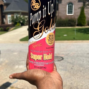 May include: A black and pink hair styling spritz can with the text "Pump it Up! Gold" and "Super Hold". The can contains 8 fl. oz. (237 mL) of product. The product is designed to instantly freeze hair in place.