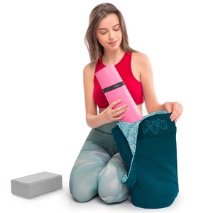 girl putting away yoga accessories in the yoga bag