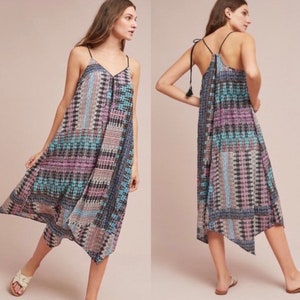 May include: A sleeveless maxi dress with a geometric pattern in shades of blue, pink, and black. The dress has a V-neckline and a tie at the back.