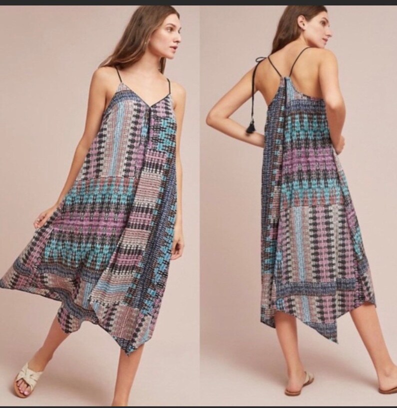 May include: A sleeveless maxi dress with a geometric pattern in shades of blue, pink, and black. The dress has a V-neckline and a tie at the back.