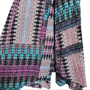 May include: A black and white patterned skirt with pink, blue, and turquoise accents. The skirt has a geometric design and a flowing silhouette.