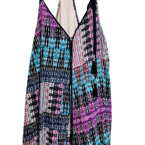 May include: A sleeveless, black, purple, and blue patterned dress with a V-neckline and a zipper down the front.